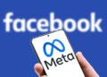 Moscow - 29 Oct, 2021: Meta logo on screen of mobile phone on Facebook word background. Facebook after rebranding and changing name to Meta. Facebook is social networking. Marketing and trend concept