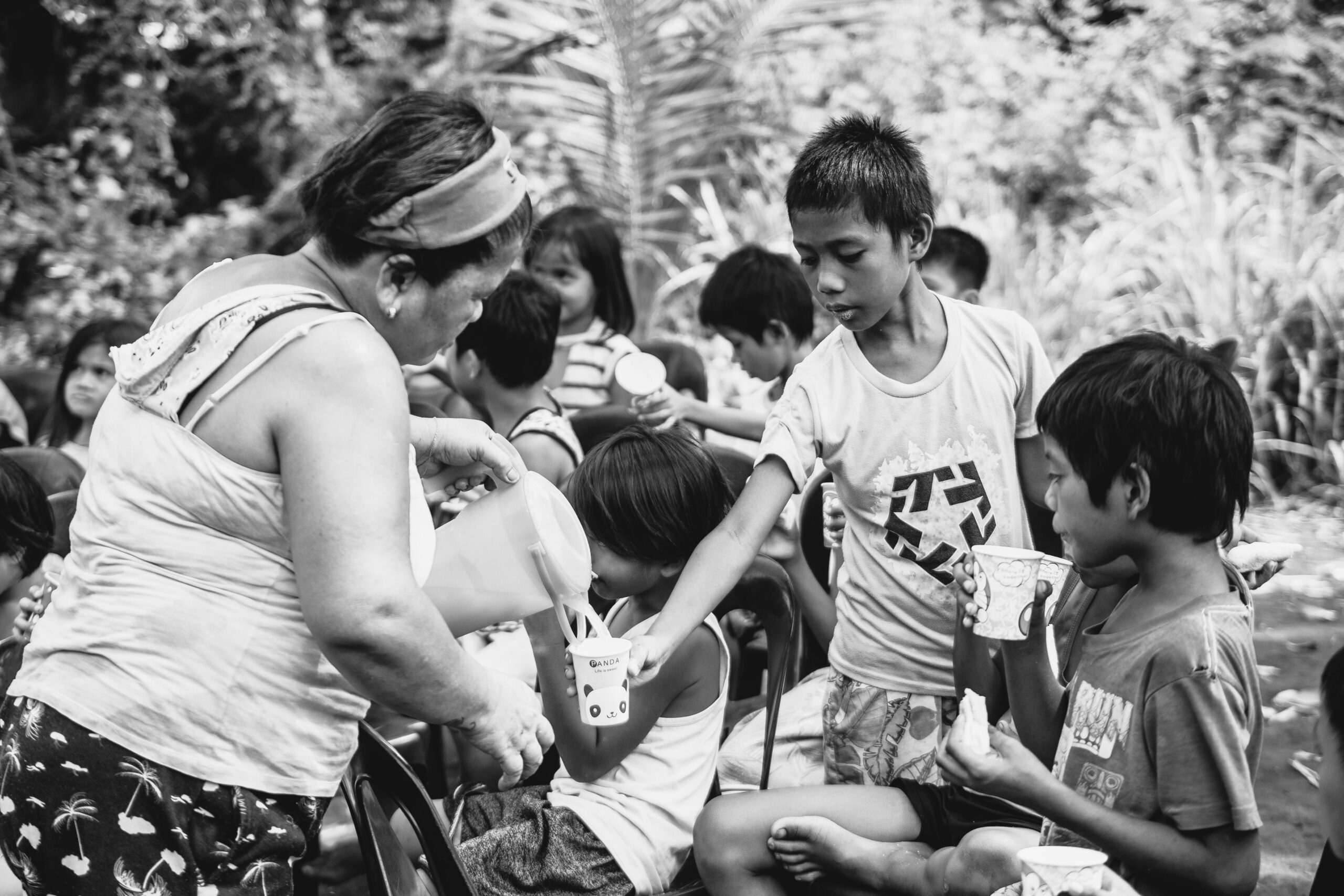 Mulher sorrindo enquanto usa um notebook em um ambiente de trabalho iluminado.
